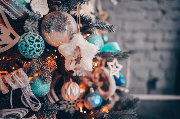 Detalhes de uma árvore de Natal decorada nas cores turquesas e laranja escuras