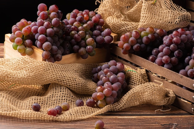 Detalhes de uvas de lindas uvas em uma caixa rústica em uma mesa de madeira rústica foco seletivo