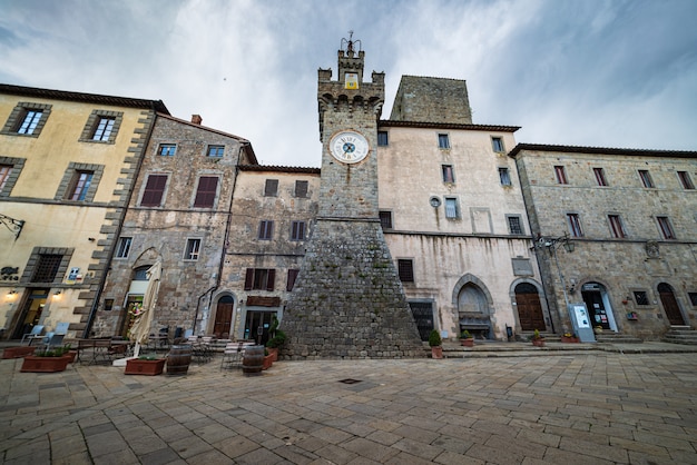 Detalhes de vilas medievais italianas, praça de pedra histórica e torre do relógio antiga, arquitetura de edifícios de pedra da cidade velha. santa fiora, toscana, itália.