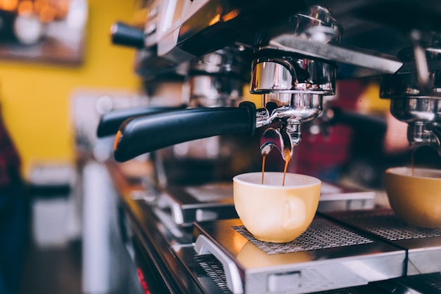 Detalhes do barista preparando café expresso fresco em máquinas industriais de fabricação de cerveja