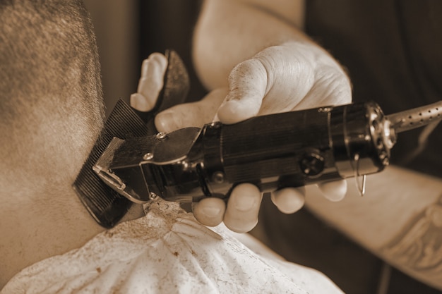 Foto detalhes do corte de cabelo. cortada closeup de um barbeiro de barbear atrás da cabeça para seu cliente