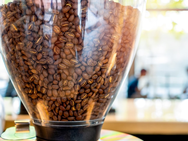 Detalhes texturizados de grãos de café em uma máquina preparando-se para misturar na cafeteria ou no fundo do café com a luz do sol pela manhã