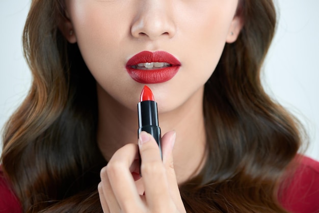 Detalle de una bella mujer aplicando lápiz labial