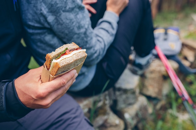 Detalle de un bocadillo que se va a comer una pareja haciendo una pausa para hacer trekking