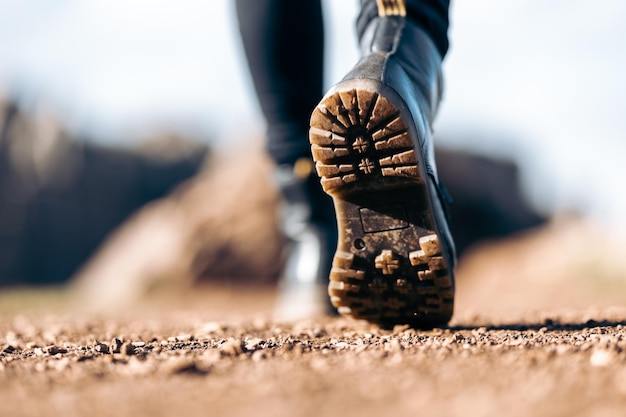 Detalle de las botas de una mujer joven caminando por el campo