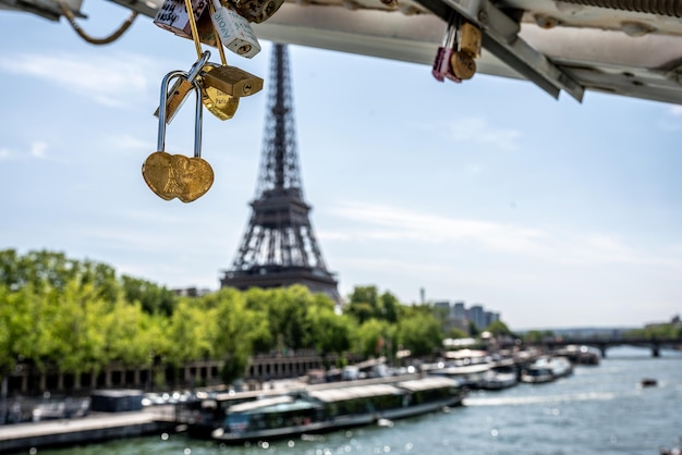 Detalle de un candado de amor con el río Sena y la Torre Eiffel al fondo en París Francia