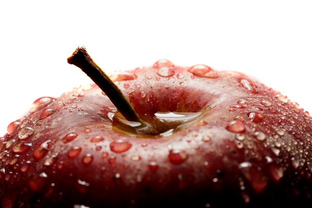 Foto detalle cercano de la visión de una manzana roja aislada en un fondo blanco.