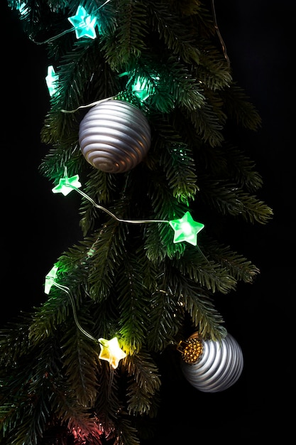 Detalle de la corona de Navidad con luces LED de colores y bolas de primer plano sobre fondo oscuro