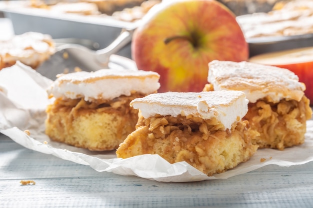 Detalle de cortes de pastel de apliques en una servilleta con una manzana fresca en el fondo.