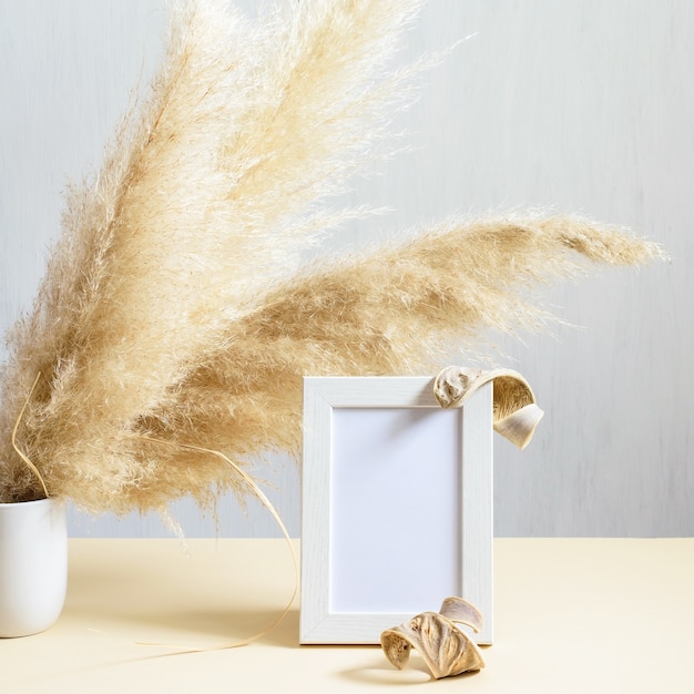 Detalle de la decoración de interiores con phragmites de plantas naturales y marco de fotos de madera