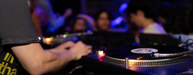 Detalle de DJ consular con enfoque selectivo en el tocadiscos mientras se mezcla en un concierto