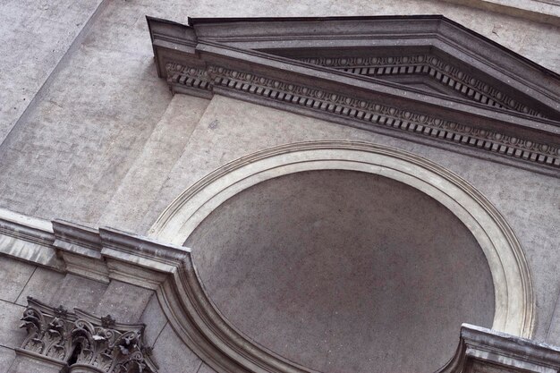 Detalle de la fachada de un edificio clásico y fondo de ciudad con textura gris