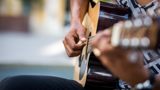 Detalle del guitarrista latino tocando la guitarra en la calle