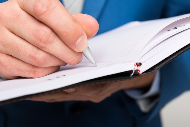 Foto detalle de un hombre de negocios tomando notas