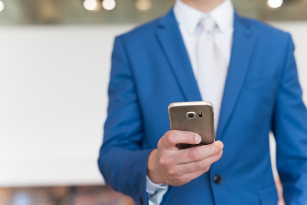 Detalle de un hombre de negocios usando su teléfono móvil