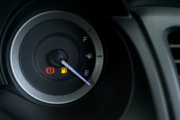 Detalle con los indicadores de combustible mostrando y tanque vacío en el tablero del automóvil