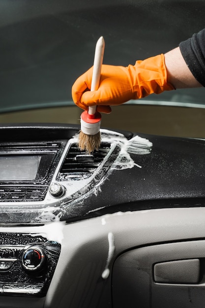 Detalle del interior del coche Sistema de aire de limpieza con espuma y detergente utilizando un cepillo Trabajador en el servicio de limpieza de automóviles Limpie el interior del coche