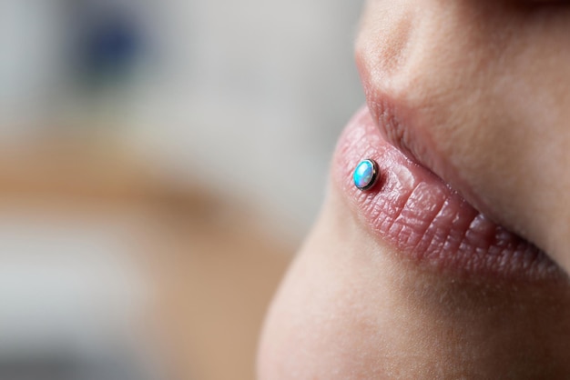 Foto detalle de un labret piercing en la boca de una mujer sonriente