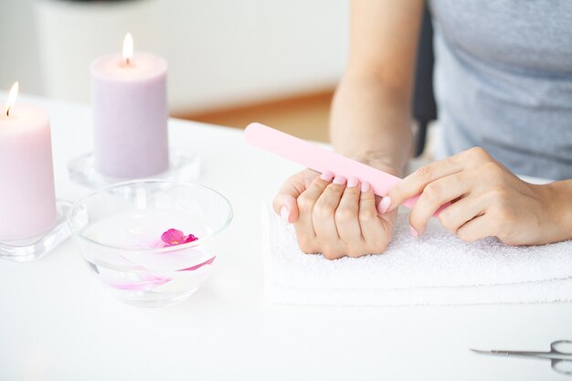 Detalle de manicura de uñas con lima o pincel.