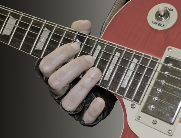 Detalle de la mano del hombre tocando una guitarra eléctrica