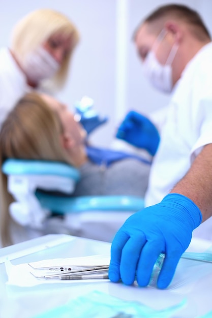 Detalle de la mano que sostiene las herramientas dentales en la clínica dental Concepto de dentista