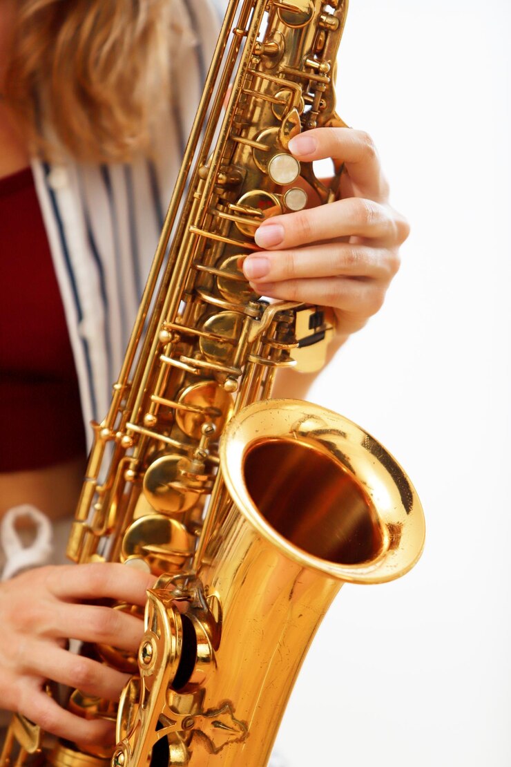 Foto detalle de las manos de una mujer tocando el saxofón