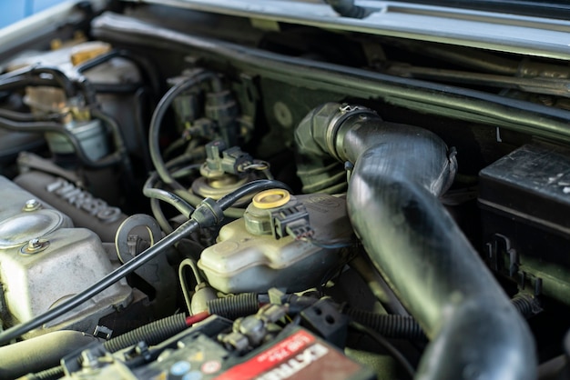 Detalle de un motor usado con piezas mecánicas a la vista dentro de un automóvil