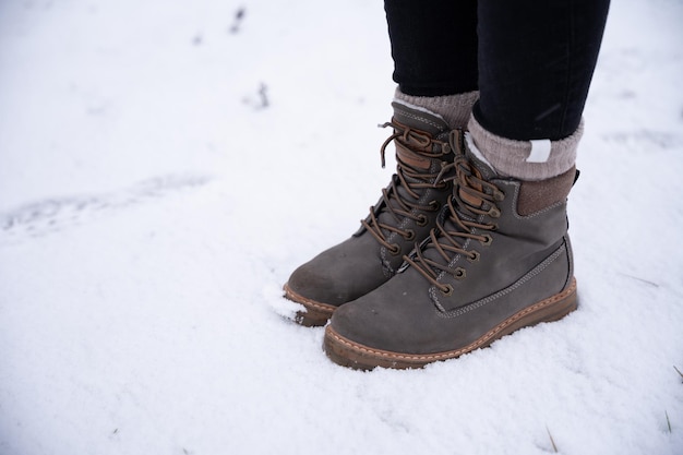 Detalle de una mujer irreconocible botas en la nieve en botas concepto de invierno