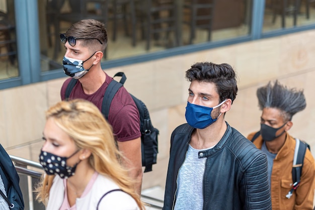 Foto detalle de las multitudes en la ciudad caminando durante el brote del virus de la corona personas multirraciales con rostros cubiertos con máscaras protectoras nuevo concepto normal