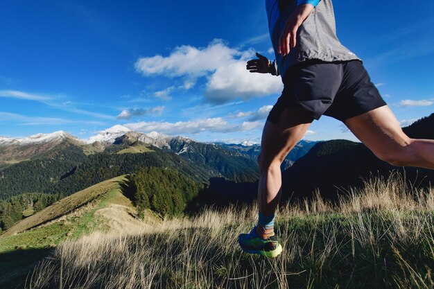 Foto detalle de las piernas de un corredor de montaña durante un entrenamiento de descenso