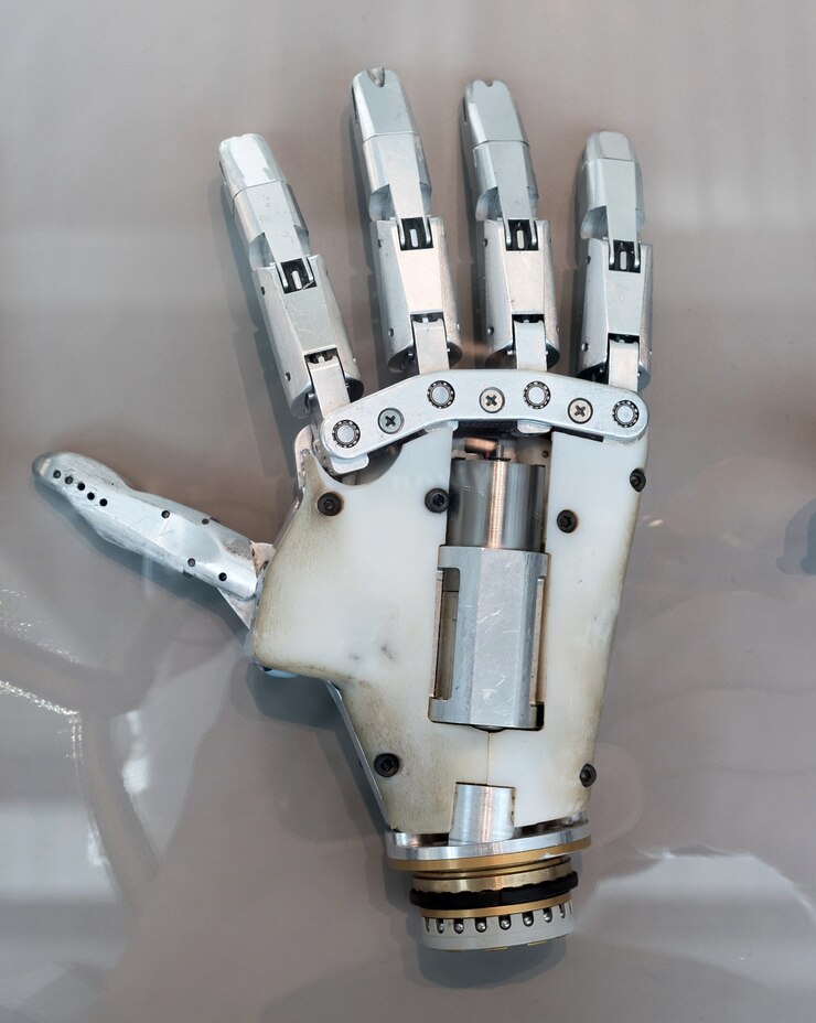 Foto detalle de una prótesis de mano humana con articulaciones articuladas para su uso como miembro de reemplazo después de una amputación en una vista con la palma hacia abajo