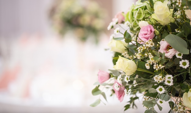 Detalle de un ramo de flores de boda con rosas rosadas situado en el lado derecho de la imagen.