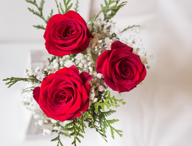 Detalle de ramo de rosas rojas con fondo blanco y espacio para escribir.