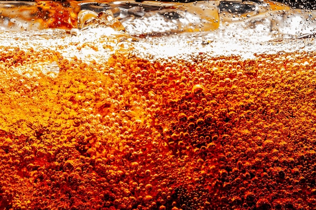 Detalle de refresco carbonatado burbujeante frío con hielo