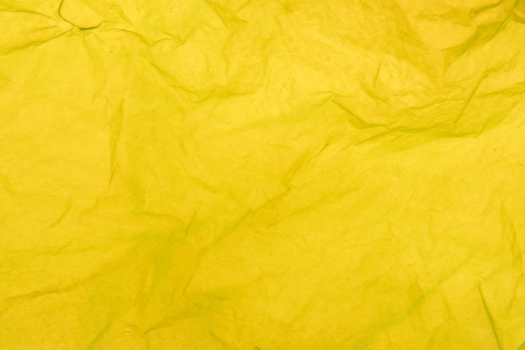 Foto detalle de la textura de una bolsa de plástico amarilla.
