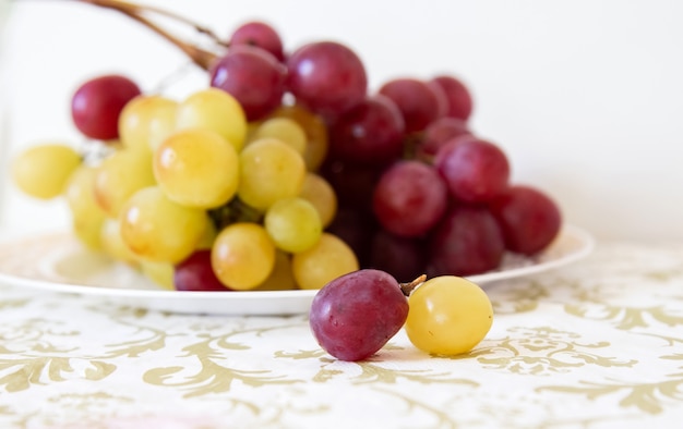 Detalle de uvas blancas y rojas sobre una mesa