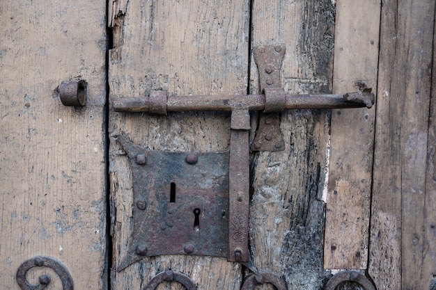 Detalle de una vieja cerradura de una puerta oxidada y con la madera vieja