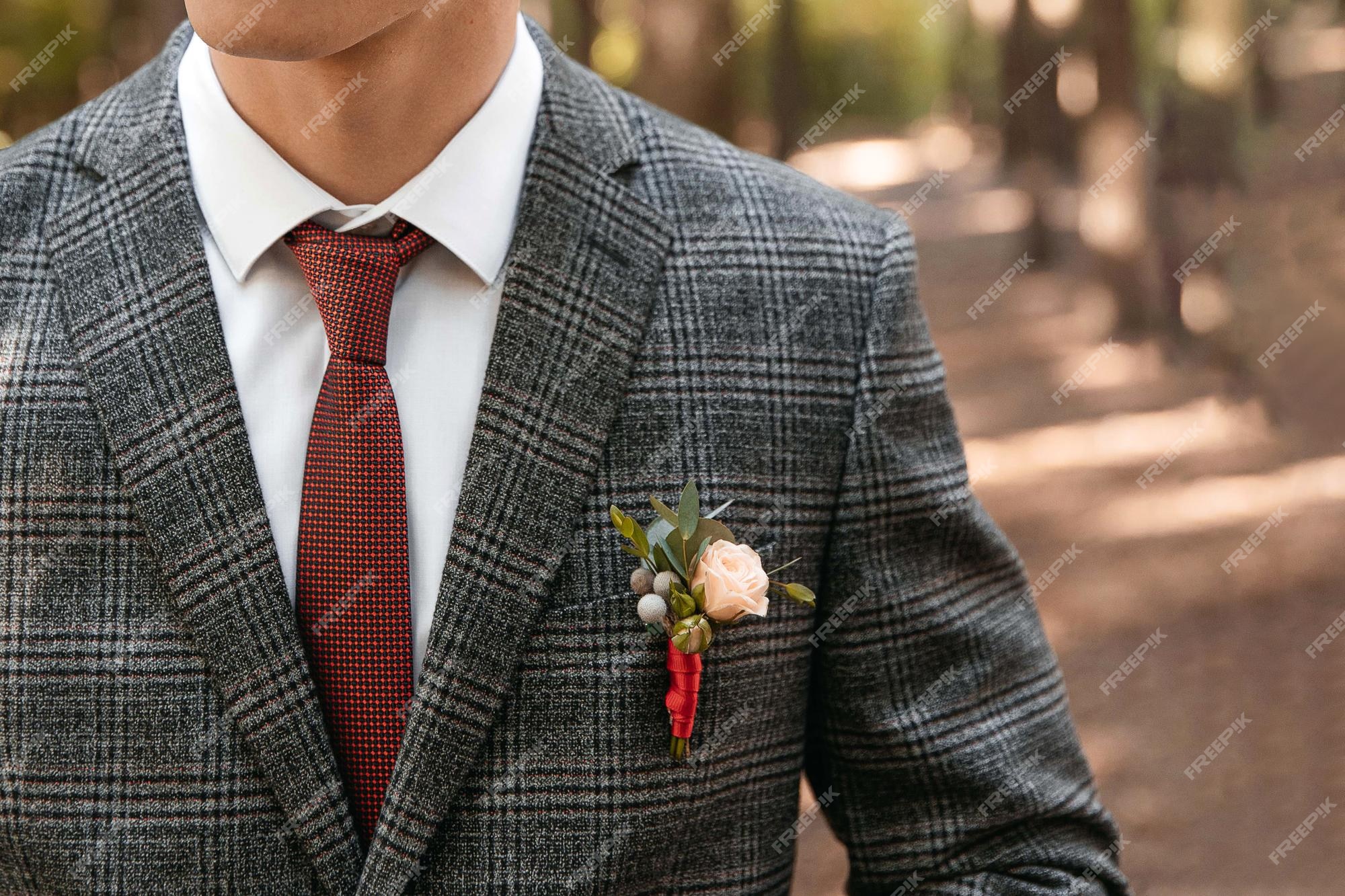 en la chaqueta del novio boutonniere de corbata roja y traje gris | Foto Premium