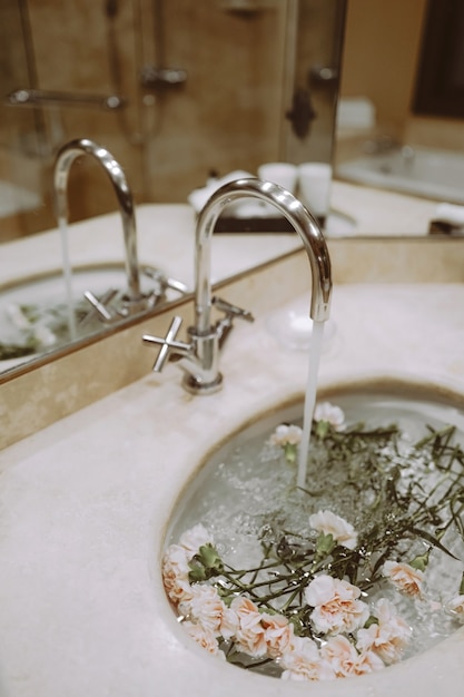 Detalles del interior del baño con flores en el lavabo.