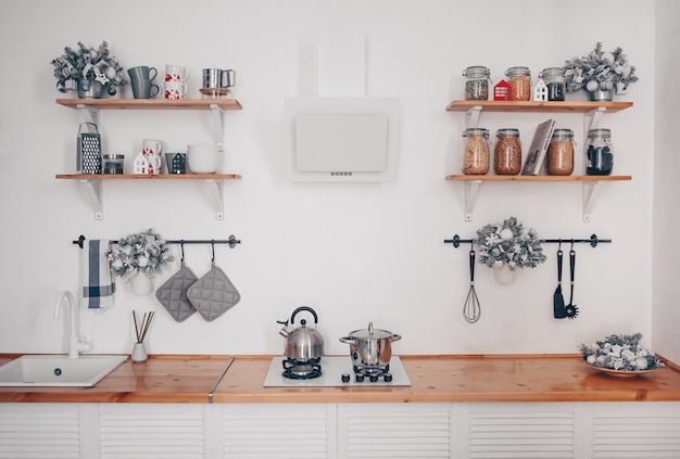 Detalles del interior de la moderna cocina blanca con estilo con elementos de madera en un apartamento de estilo escandinavo