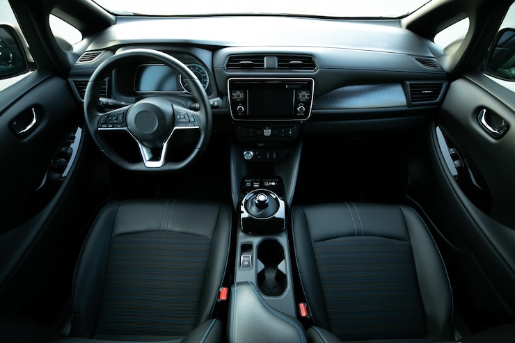 Foto detalles interiores del coche eléctrico de la manija de la puerta con controles y ajustes de ventanas. interior del automóvil con asientos delanteros, conductor y pasajero, textil, ventanas, paneles de puertas, consola