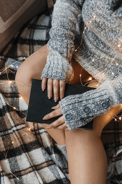 Detalles de mujer sosteniendo un libro y luces de colores.