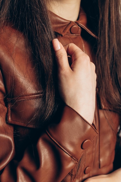 Foto detalles mujer con vestido de cuero marrón y cabello largo