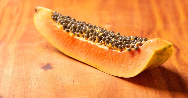 Detalles de papaya de una rodaja de papaya cortada sobre un enfoque selectivo de madera rústica