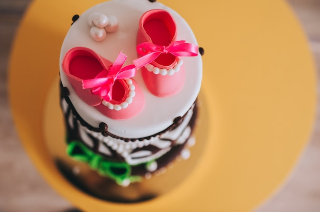 Detalles de un pastel de cumpleaños para niña con dulces zapatos de azúcar en la parte superior