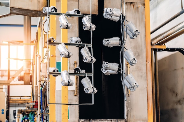 Detalles de producción colgados en perchas de metal en el taller Fuertes herramientas industriales ásperas