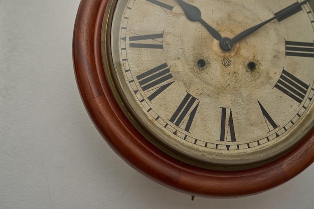 Detalles de un reloj antiguo en la pared blanca