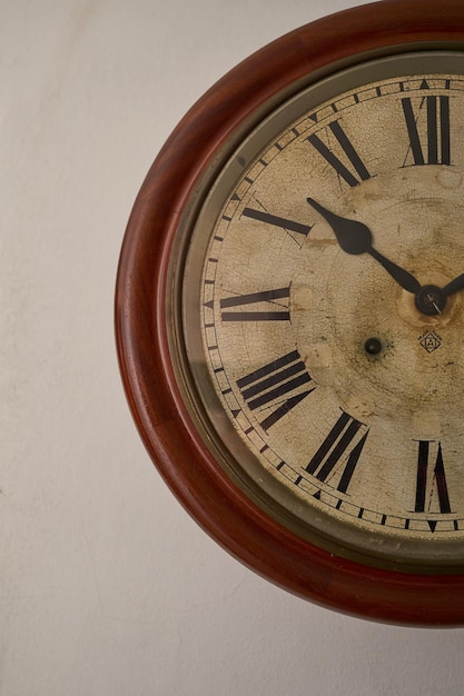 Detalles de un reloj antiguo en la pared blanca