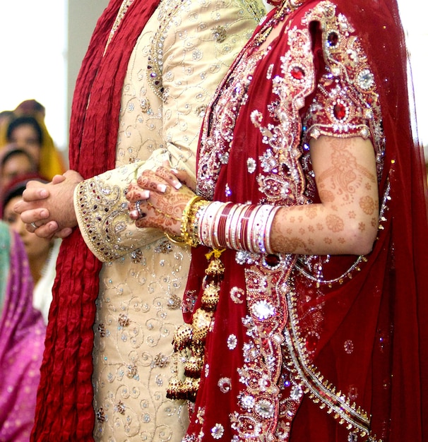 Foto detalles de la ropa del novio y la novia en la boda de punjabi, accesorios de boda india