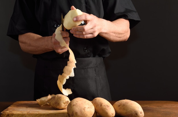 Detallle de un chef cortando patatas